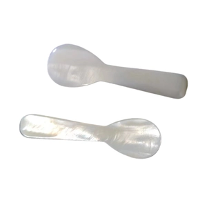 Pair of handcrafted white mother of pearl spoons for caviar and coffee on white background
