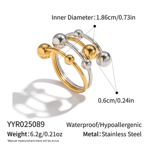 Detail view of two-tone stainless steel layered ring showing ball charms and sizing data