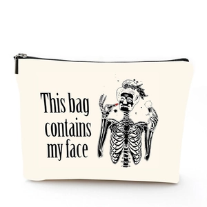 Detail of linen makeup bag featuring a skull print and 'This bag contains my face' text