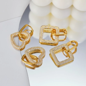Detailed view of luxury gold heart and square hoop earrings with micro-pave white zircons