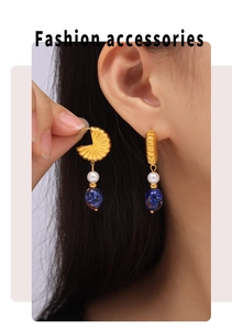 Detail von goldenen Fächerohrringen mit Perlen und blauem Lapislazuli am Model