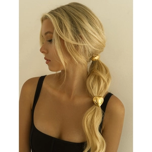 Polished heart-shaped 18k gold hair tie accessory shown on blonde model's hair