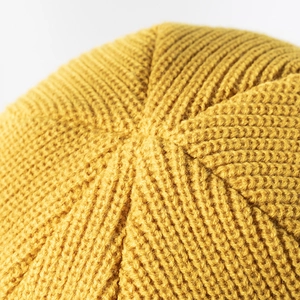 Short mustard yellow knitted beanie hat with thick ribbed texture and stylish top stitching