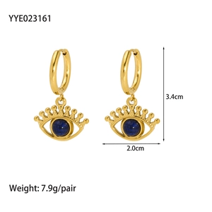 Gros plan sur boucles d'oreilles œil dorées avec lapis-lazuli, taille 3,4 cm par 2,0 cm