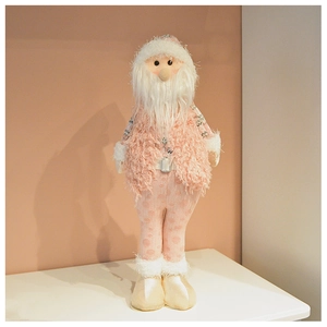 Dettaglio di Babbo Natale di peluche rosa con gilet in maglia e cappello in finta pelliccia