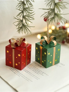 Gros plan de boîtes cadeaux lumineuses rouges et vertes avec étoiles sur un livre