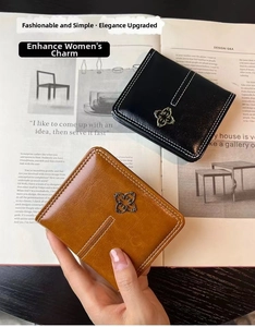 Detail of faux leather wallet showing contrast stitching and metal flower clover logo