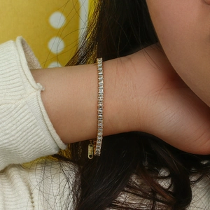 Gros plan bracelet tennis doré avec zircons carrés et chaîne de réglage ajustable