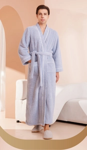 Detail of soft plush bathrobe with white contrast piping and belted waist design