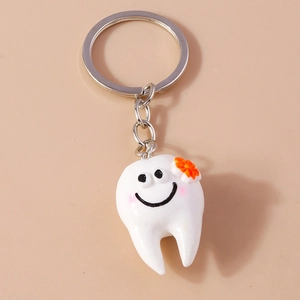 Portachiavi a forma di dente a cartone animato con piccolo fiore arancione carino