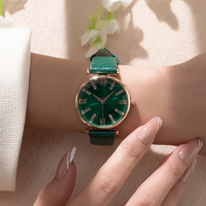 Detail of elegant women quartz watch with green leather strap and rose gold rhinestone dial