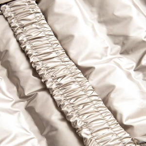 Close-up of metallic silver waterproof fabric with detailed elastic pleated stitching