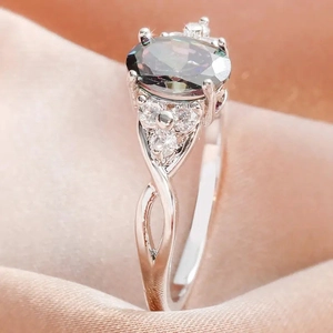 Gedraaide ring met regenboog mystieke topaas en diamantaccenten op satijnstof