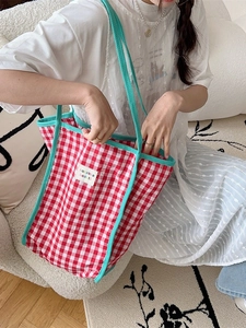 Retro red and green plaid canvas tote bag with white woven label shown on model