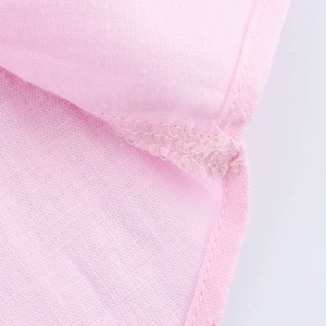 Detailed close-up of stitching on a pink linen long-sleeve shirt for women