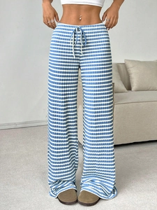 Detail of high waisted wide leg trousers with blue and white stripes and drawstring waist