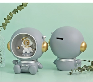 Detailed view of grey astronaut piggy bank showing front design and back coin slot