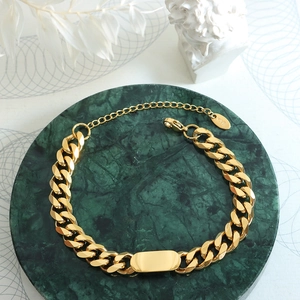 Bracelet gourmette doré avec plaque rectangulaire et poinçon or 18 carats minimaliste