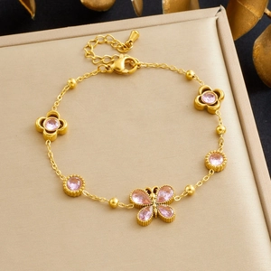 Detail of gold-plated chain bracelet with pink zircon butterfly and flower charms