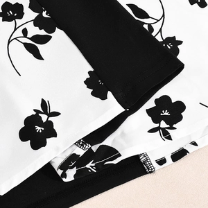 Détail du motif floral noir sur tissu blanc avec des finitions de couture impeccables