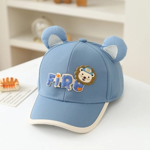 Détail d'une casquette bébé avec oreilles 3D et écusson lion en couleur bleu ciel