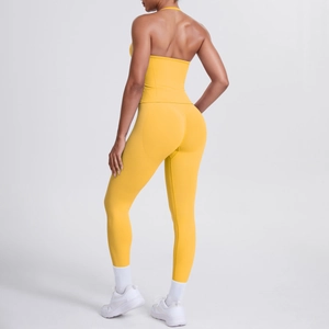Detailansicht von gelbem Neckholder-Top und Yoga-Leggings mit hoher Taille an Model im Studio