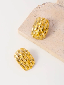 Detail shot of golden rectangular earrings with intricate woven texture and metallic finish