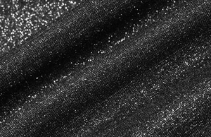 Gros plan sur un tissu noir scintillant avec paillettes argentées et texture en maille
