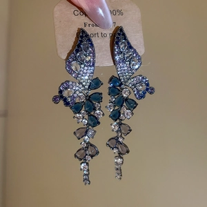 Detailed macro view of blue zircon butterfly drop earrings with shimmering gemstones