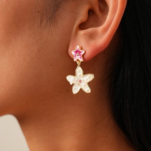 Close-up of double-layered floral earrings with pink rhinestones on a female model