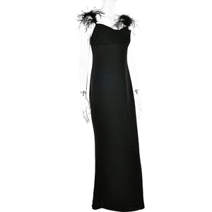 Détail d'une robe de soirée noire avec plumes sur les bretelles et coupe ajustée élégante