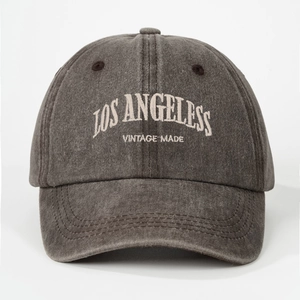 Detail of embroidered LOS ANGELES lettering on vintage washed grey baseball cap fabric