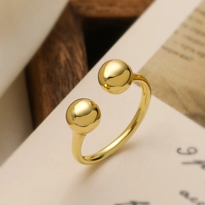 Minimalist gold plated open ring featuring dual polished spherical beads on cream card