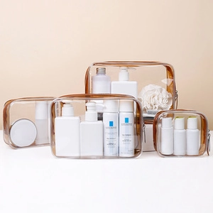 Detail of four transparent PVC travel bags with brown zipper trim for toiletries