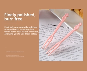 Detail of pink plastic fruit forks with two-tines design on a dessert plate