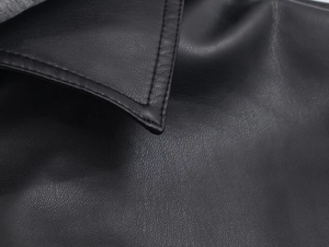 Macro shot of high-quality black faux leather jacket collar with precision stitching