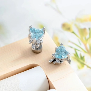 Lava heart zircon cartilage stud earrings with light blue gemstone and silver cross detail