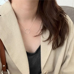 Close-up of minimalist S925 sterling silver circle pendant necklace on a female model
