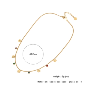 Detail of gold stainless steel necklace with floral charms and colorful glass pendants