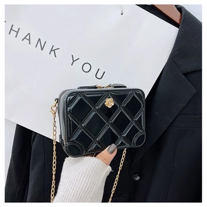 Detail of black PVC jelly bag with quilted pattern, gold chain and flower clasp