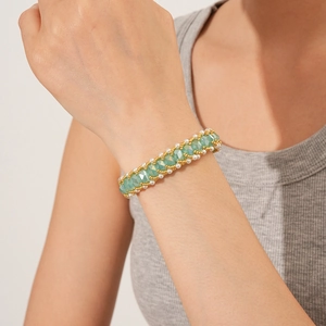 Detail of vintage woven titanium steel bracelet with green crystals and pearls on wrist
