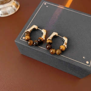 Vintage gold-plated hoop earrings with tiger eye stone beads on a black gift box