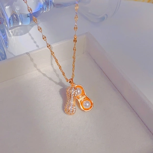 Élégant collier cacahuète en or rose avec zircons blancs et perles sur boîte à bijoux