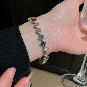 Detail of a luxury clover bracelet with colorful zircons worn in an elegant setting