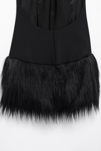 Nahaufnahme des eleganten Neckholder-Kleids mit schwarzem Stoff und Webpelz-Besatz