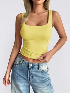 Close-up of a yellow square neck sleeveless crop top worn by a model in a studio setting