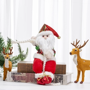 Detail of plush Santa Claus doll on vintage books with festive reindeer decor