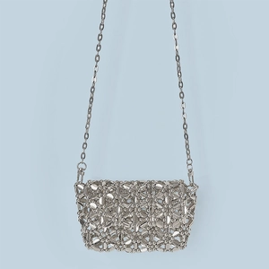 Close-up of silver beaded crossbody bag featuring intricate floral woven patterns and chain