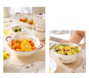 Detailed view of floral ceramic bowls with double handles and purple rim decoration