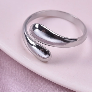 Macro shot of silver minimalist open ring featuring a double teardrop crossover design